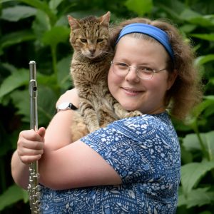 Anthea Conway-White holding a flute and a cat.
